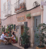 Giovana enjoying a chic outdoor café with tropical plants.